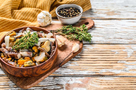 Seafood mix in a wooden bowl. mussels, clams, squid, octopus, shrimps and prawn. White background. Top view. Copy space.の写真素材