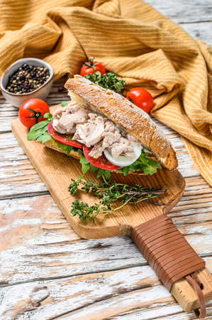 Sandwich with homemade liver pate, arugula, tomato, egg and herbs. White wooden background. Top view.の写真素材