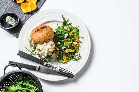 homemade hamburger with blue cheese, marbled beef and onion marmalade, a side dish of salad with...