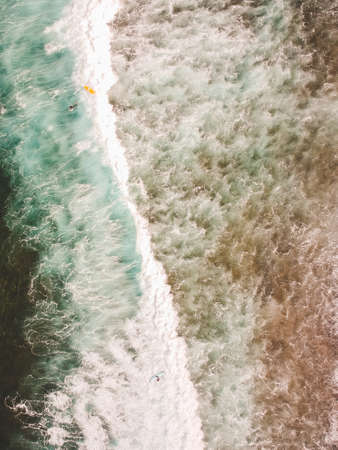 Aerial view of surfers in the waves of the Atlantic ocean. Sandy beach. Panorama background shot on...