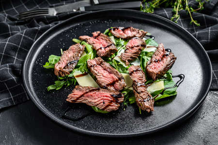 Steak salad with spinach, arugula and sliced beef marbled steak. Black background. Top view.の写真素材