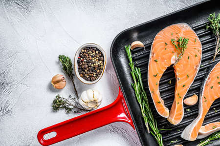 Salmon fillet steak in a pan. Raw fresh fish. White background. Top view. Copy space.の写真素材