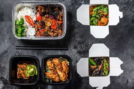 Spring rolls, dumplings, gyoza and wok noodles in Take away box. Healthy lunch. Take and go organic food. White background. Top view.の写真素材