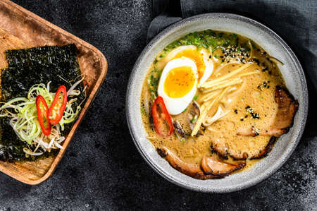 Ramen asian noodle soup with Beef tongue meat, mushroom and Ajitama pickled egg. Black background. Top view.の写真素材
