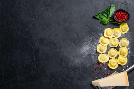 Raw ravioli. The process of making homemade Italian ravioli. Black background. Top view. Space for text.の写真素材