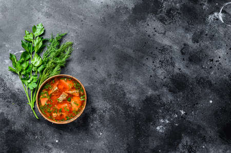 National Russian and Ukrainian Borsch beetroot soup in a wooden bowl. Black background. Top view. Space for text.の写真素材