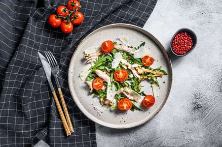 Salad with chicken, arugula, walnuts, tomatoes and Parmesan. gray background. Top view.の写真素材