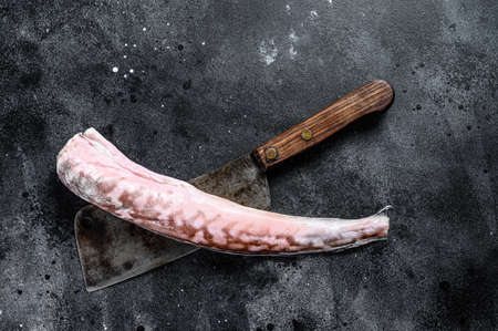 Raw king klip, congrio fish on a cleaver. Black background. Top view. Copy space