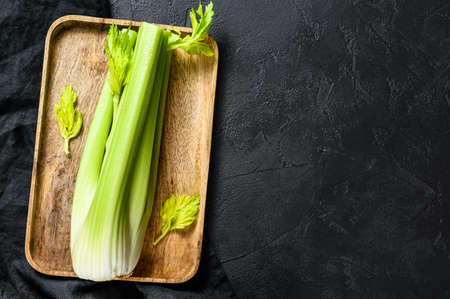 Bunch of fresh celery stalk with leaves. Black background. Top view. Space for text.の写真素材