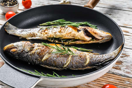 Baked sea Bass fish, grilled seabass. White wooden background. Top view.の写真素材