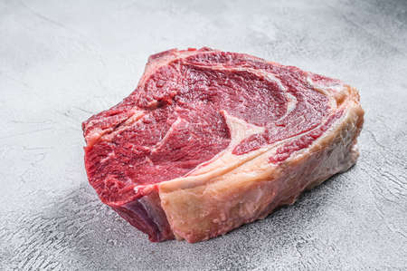 Raw cowboy steak or rib eye on the bone. Marble beef. Gray background. Top view.の写真素材
