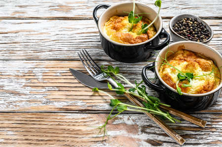Cheese omelet with micro greens in a pan. White wooden background. Top view. Copy space.の写真素材