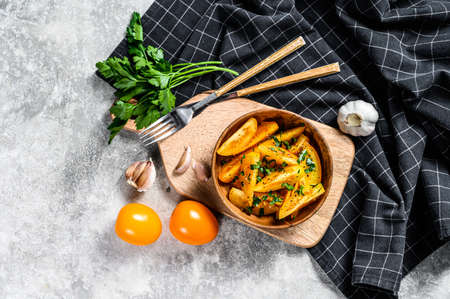 Healthy and colorful salad with yellow tomatoes and parsley. Gray background. Top view.の写真素材