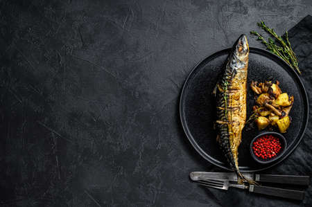 Grilled mackerel with baked potatoes and mushrooms. Black background. Top view. Space for text.の写真素材