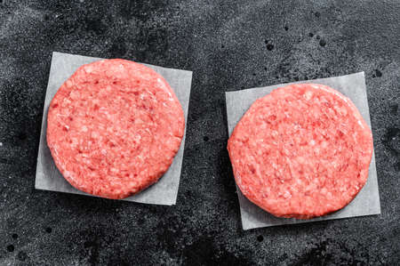 Raw Burger patties, ground beef meat. Black background. Top view.