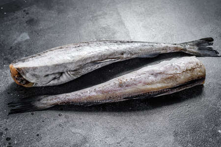 Raw Pollock fish ready to cook. Black background. Top view.