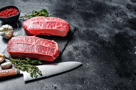 Raw organic meat Twagyu oyster top blade steak. Black background. Top view. Copy space.の写真素材