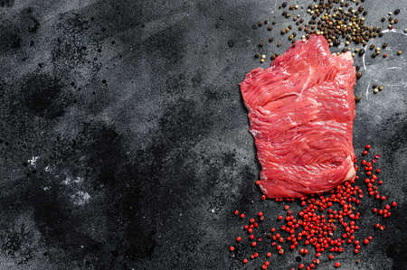 Raw Flank steak with black and pink pepper. Black background. Top view. Copy space.の写真素材