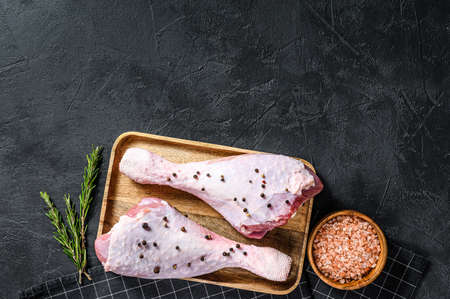 Raw chicken thigh with spices. Black background. Top view. Space for text.の写真素材