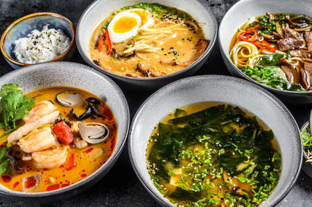 Assorted traditional Asian soups. Miso, Ramen, Tom Yam, Pho Bo. Black background. Top view.の写真素材