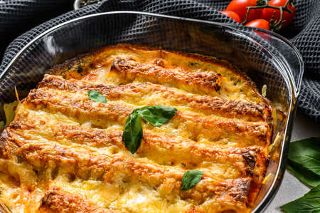 Stuffed cannelloni with bechamel sauce. Pasta baked with beef meat, cream sauce, cheese. Gray...