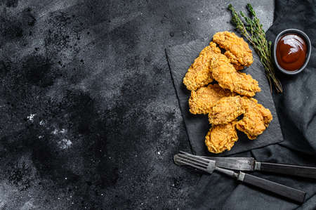 Spicy Deep Fried Breaded Chicken Wings. Black background. Top view. Copy space.の写真素材