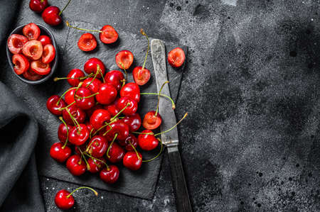 Red Cherries on black cutting board. fresh cherries. Black background. Top view. Copy space.の写真素材