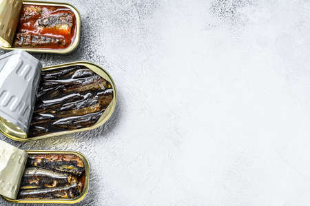 Assorted canned fish in a tin sardine, smoked sardine, mackerel. Gray wooden background. Top view. Copy space.の写真素材