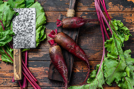 Purple beetroot on a cutting board. Dark wooden background. Top view.の写真素材
