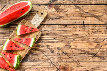 Slices of red striped watermelon. Wooden background. Top view. Copy space.の写真素材