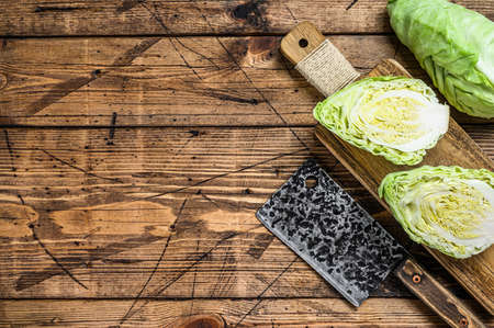 Raw Cutting Pointed white cabbage head on a cutting board. Wooden background. Top view. Copy space.の写真素材