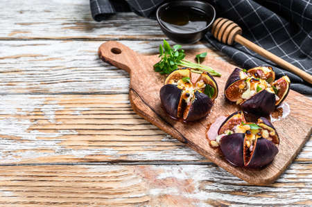 Oven-baked figs with gorgonzola, herbs and honey. White background. Top view. Copy space.の写真素材