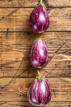 Raw purple Aubergine or eggplant. wooden background. Top view.の写真素材