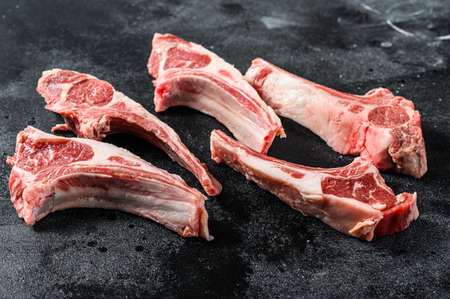 Raw lamb chops, Rack of Lamb. Organic meat steak. Black background. Top view.