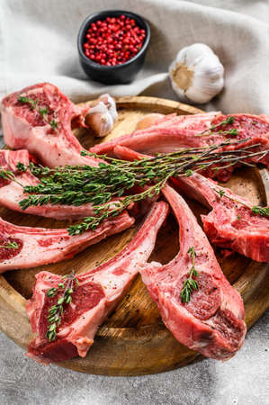 Rack of lamb, raw meat with bone, chops with salt, pepper. Gray background. Top view.