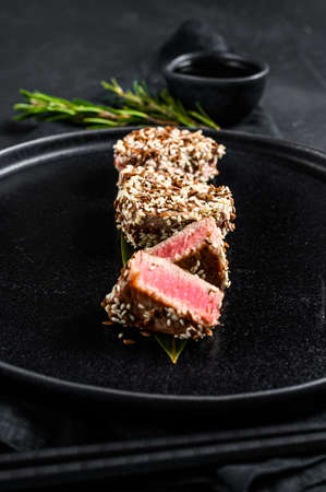 Grilled tuna steak in sesame seeds. Black background. Top view.の写真素材
