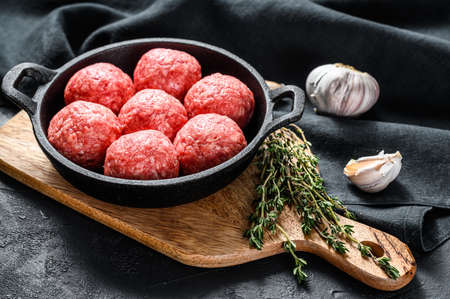 Cooking meatballs from minced meat pork in a frying pan. Black background. Top view.の写真素材