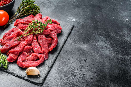 Raw beef Stroganoff meat. Black background. Top view. Copy space.の写真素材