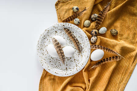 White background with white eggs and feathers. White background. Top view.の写真素材