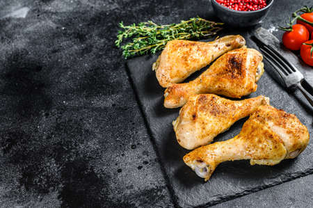 Roasted spicy chicken drumstick, shanks with spices and herbs. Black background. Top view. Copy space.の写真素材