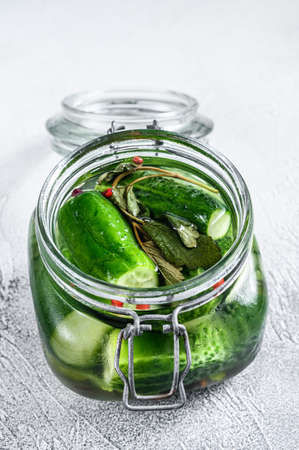 Green pickle cucumbers in a glass jar. Natural product. White background. Top view.の写真素材