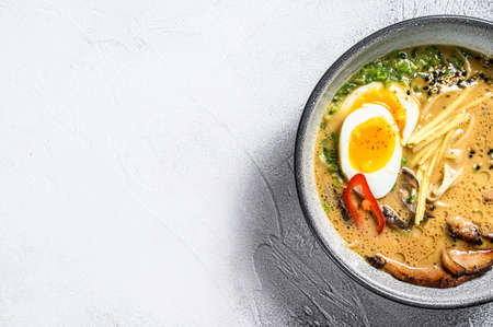 Ramen asian noodle soup with Beef tongue meat, mushroom and Ajitama pickled egg. White background. Top view. Copy space.の写真素材