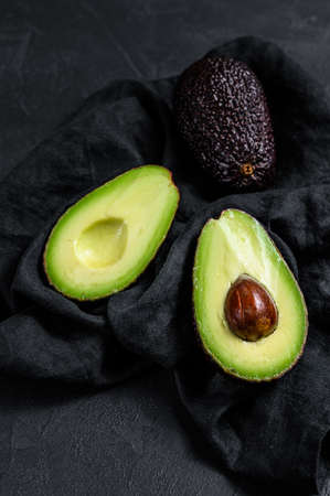 Sliced ripe avocado. Black background. Top view.の写真素材