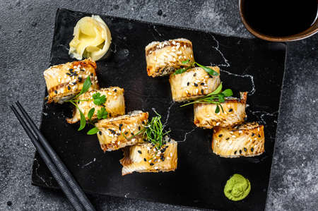 Sushi roll, Maki sushi with smoked eel and cucumber. Black background. Top view.