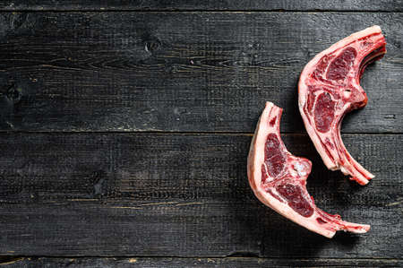 raw lamb chops fresh cut. Black background. Top view. Copy space.