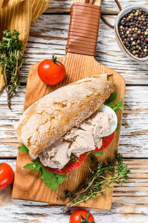 Sandwich with homemade liver pate, arugula, tomato, egg and herbs. White wooden background. Top view.の写真素材