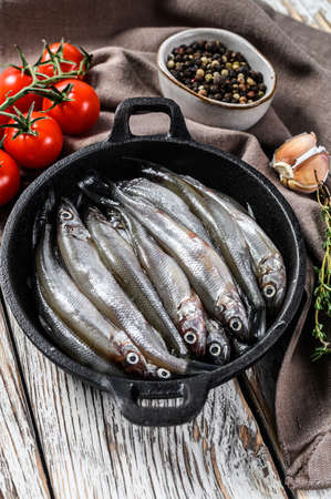 Raw smelt with pepper and thyme in a pan. White background. Top view.の写真素材