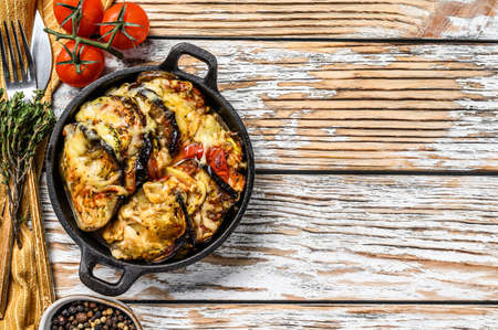 Vegetable ratatouille baked in cast-iron dish. Wooden background. Top view. Copy space.の写真素材