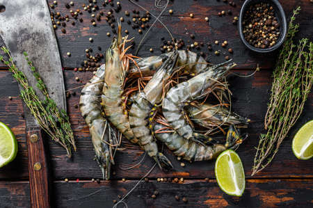 Fresh tiger shrimps, prawns with spices and herbs. Black woodenbackground. Top view.の写真素材