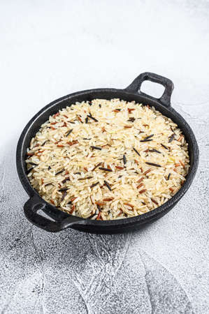 Mix rice in a cast-iron pan. White background. Top view.の写真素材